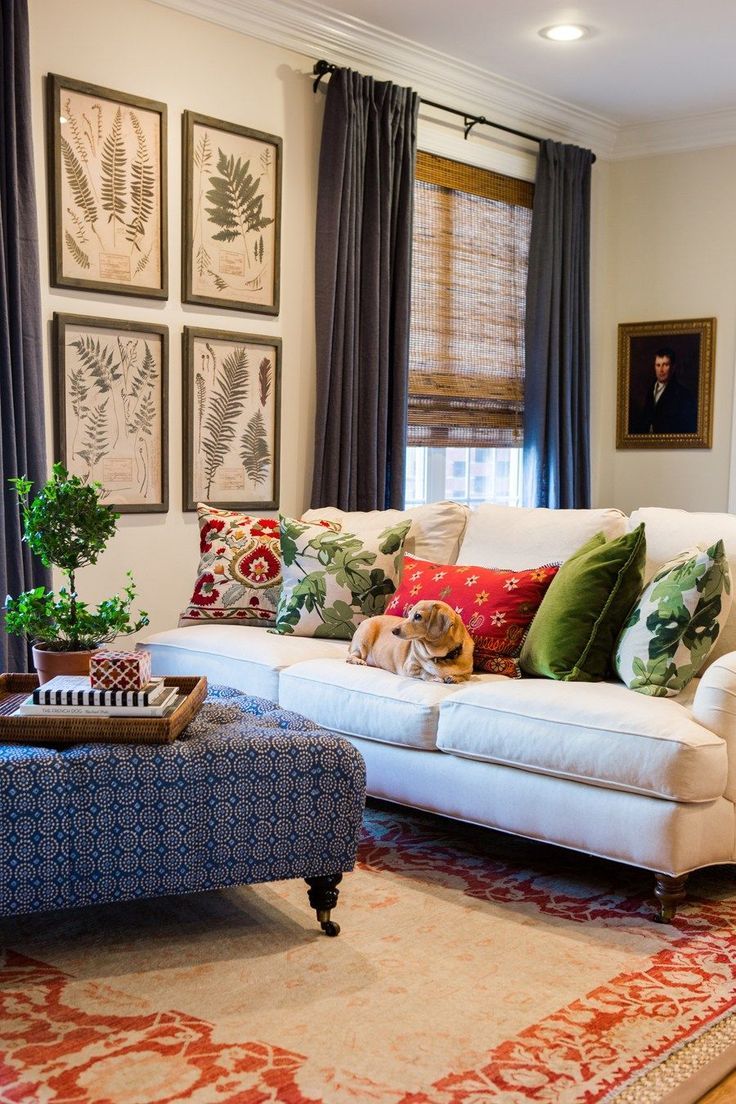 a living room filled with lots of furniture and pictures on the wall above it's windows