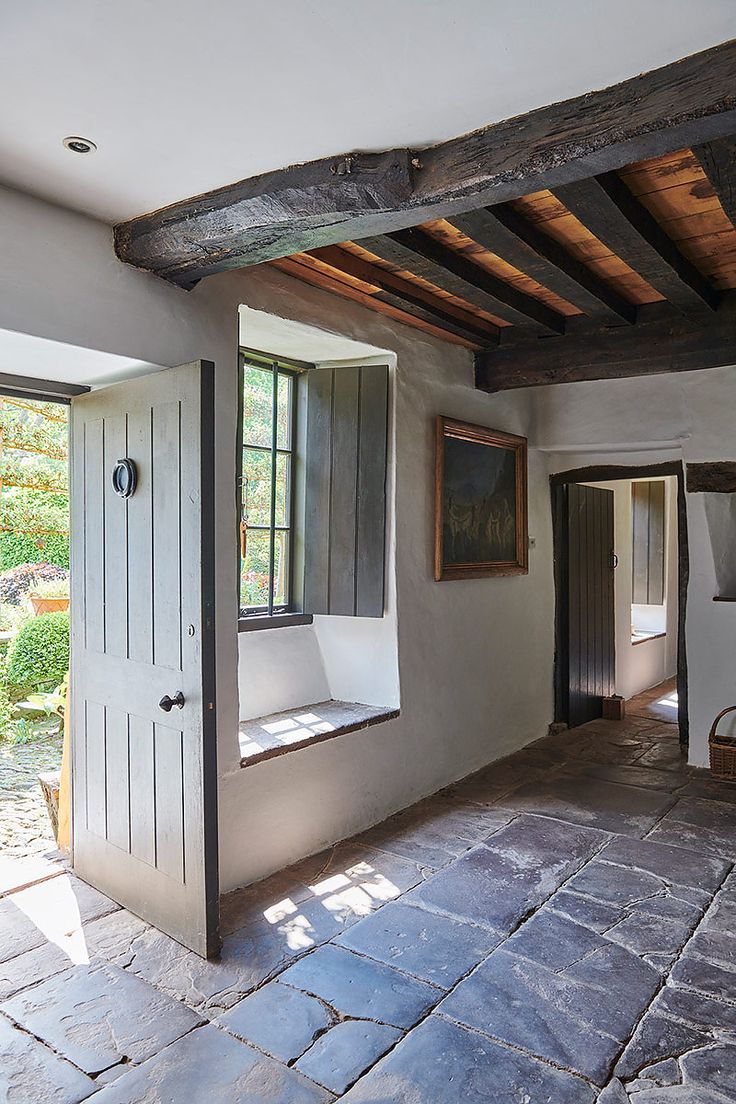 an empty room with stone flooring and exposed beams