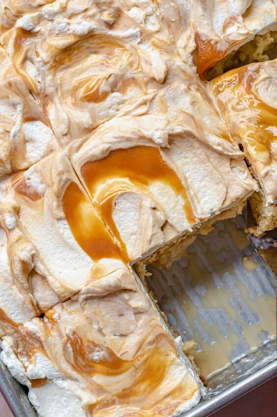 a cake with caramel icing on top is being cut into pieces and placed in a pan