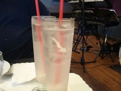 two red straws in a tall glass on a table