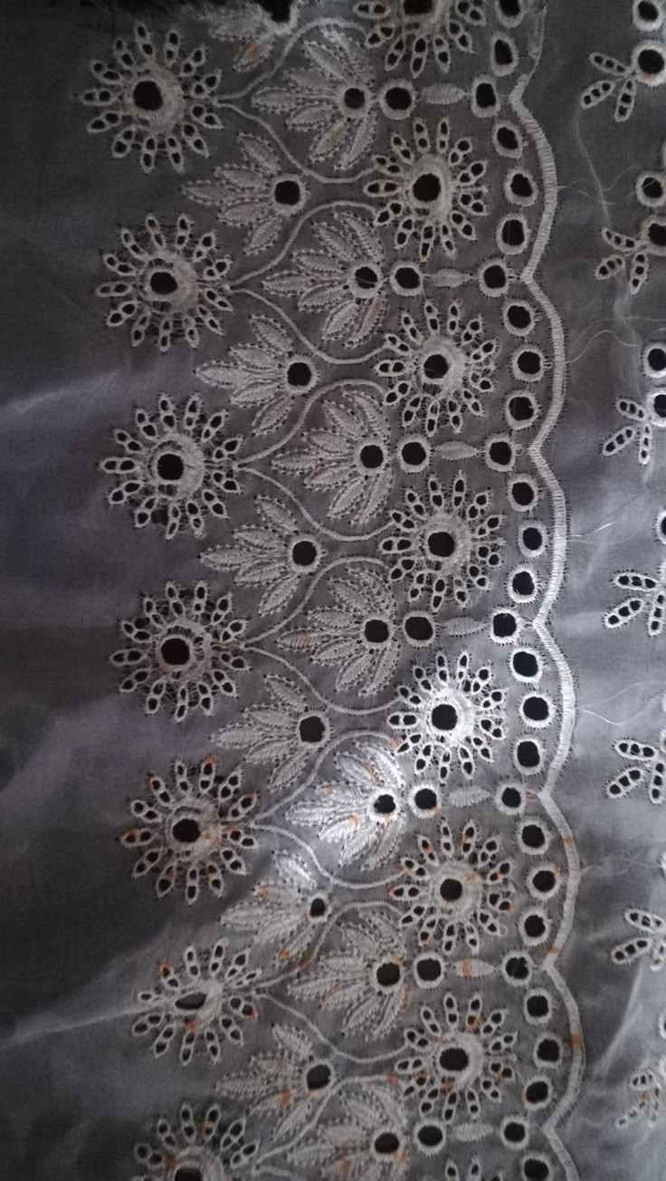 an image of a piece of cloth that has been embroidered on with holes in it