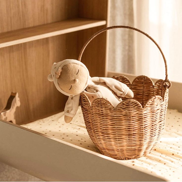 a stuffed animal in a basket on a shelf