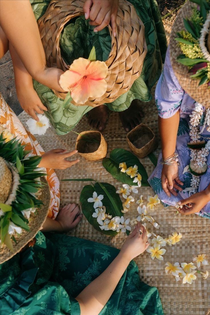 several people are sitting around with flowers in their hands and baskets on the ground next to them