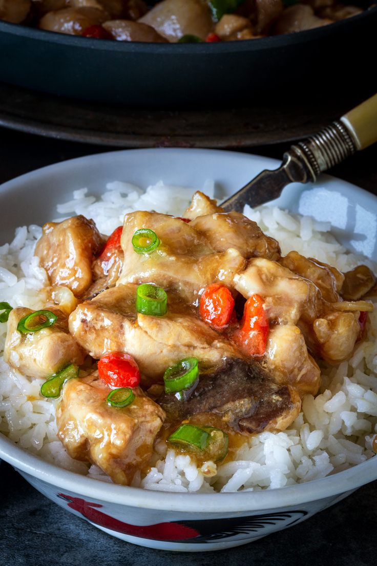 a white bowl filled with rice covered in meat and veggies