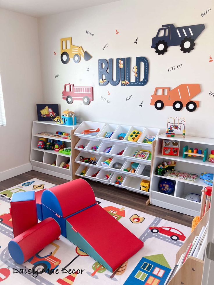 a child's playroom with toys, bookshelves and wall decals