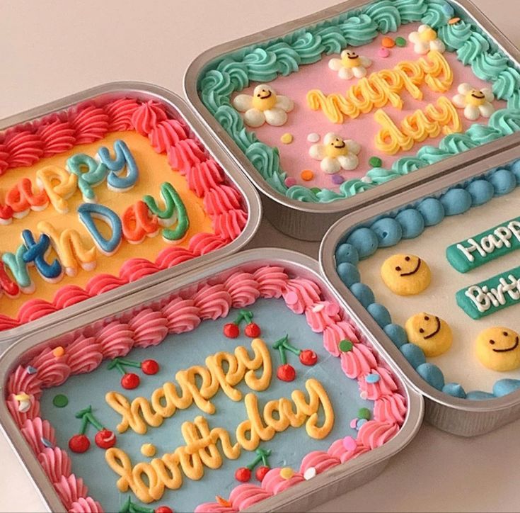 four birthday cakes in tins with happy birthday written on the frosting and decorations