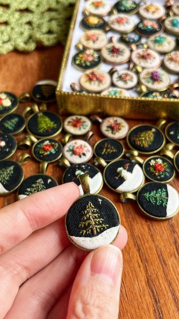 a person is holding some buttons in their hand and there are other items on the table