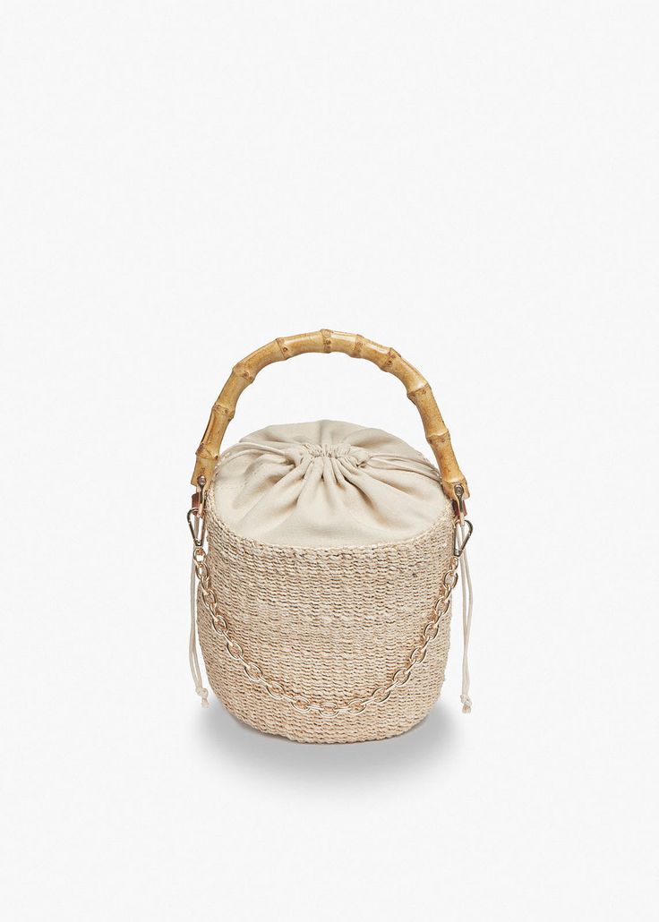 Our Ling bag is handwoven from high-quality straw and features a sturdy bamboo handle. A drawstring closure keeps your belongings secure and a gold chain adds visual interest. Handcrafted from all-natural straw. Features a drawstring lining and top handles. Measures 6.25”H by 6" Dia. with a 4.5” handle drop. Trendy Woven Jute Bucket Bag, Chic Natural Straw Bag With Bamboo Handle, Woven Top Handle Bucket Bag For Vacation, Elegant Natural Bucket Bag With Bamboo Handle, Jute Straw Bucket Bag With Bamboo Handle, Jute Straw Bag With Bamboo Handle In Bucket Shape, Jute Straw Bag With Bamboo Handle And Bucket Shape, Trendy Straw Bags With Bamboo Handle, Top Handle Bucket Bag In Natural Fiber For Vacation