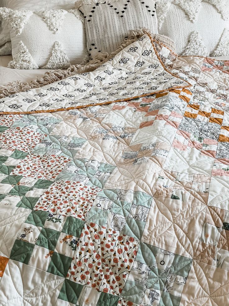 the bed is made up with white and green quilts on it's sides