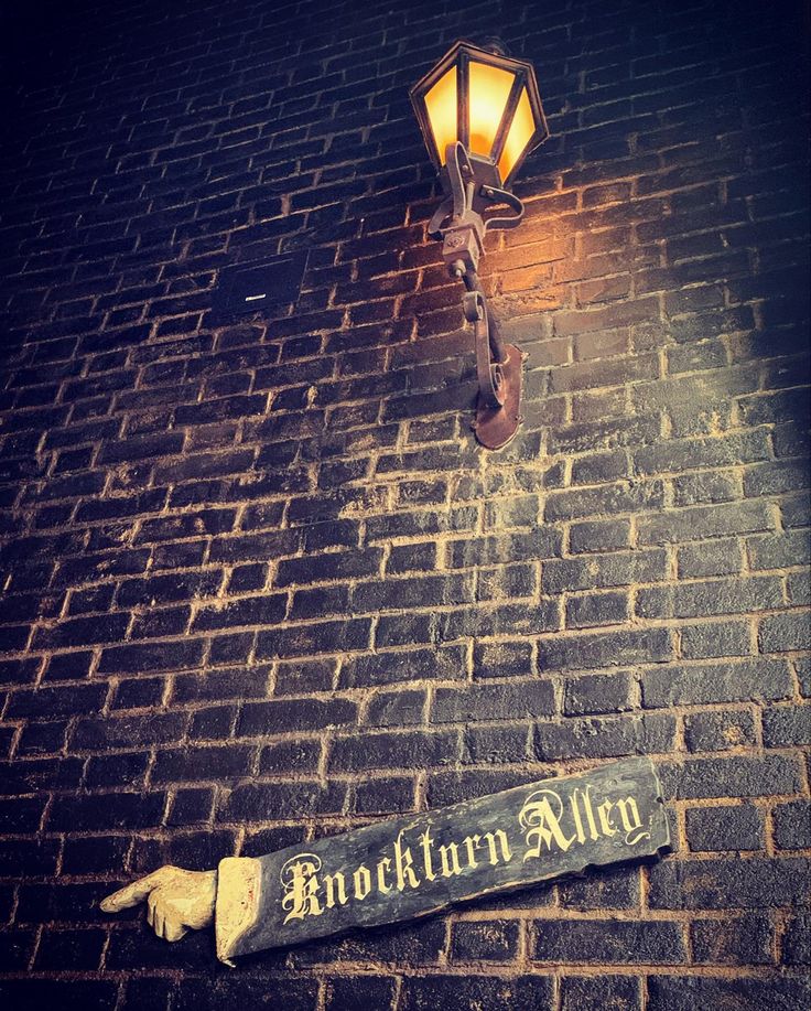 a brick wall with a street light and sign on it