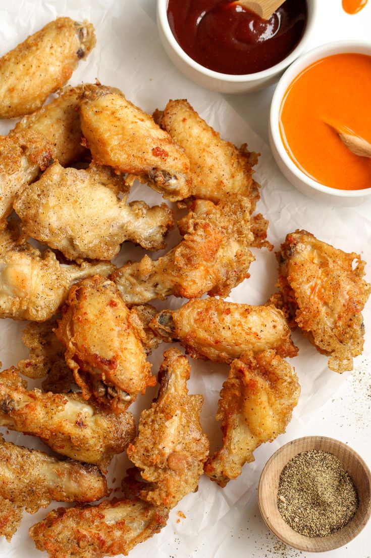 fried chicken wings with dipping sauces on the side