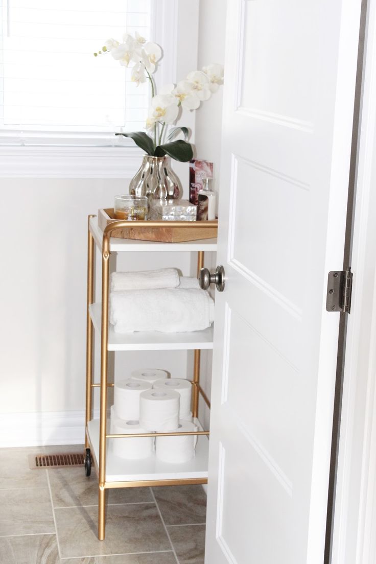 a bathroom with a gold shelf and white towels