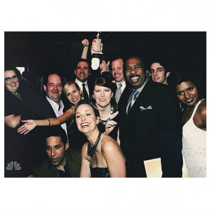 a group of people posing for a photo with an award in their hands and one person holding up a trophy