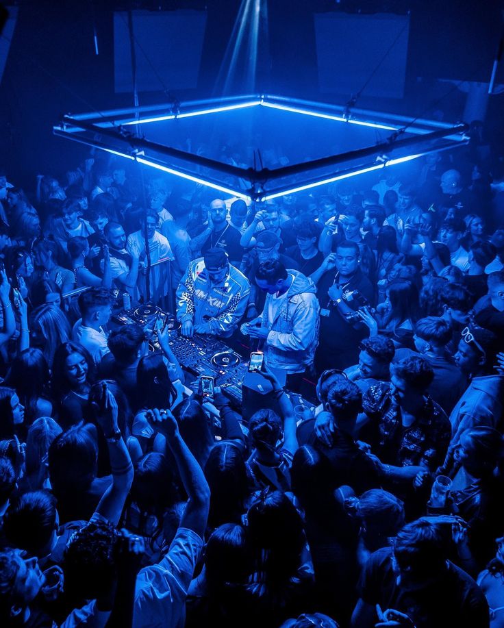 a group of people in a room with blue lights