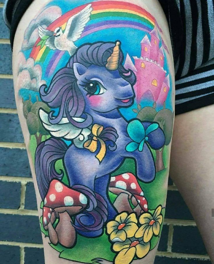 a woman's leg with a tattoo of a unicorn and mushrooms on the thigh