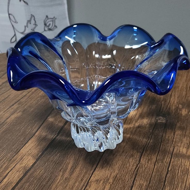 a blue glass bowl sitting on top of a wooden table