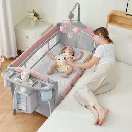 a woman is playing with her baby in the crib