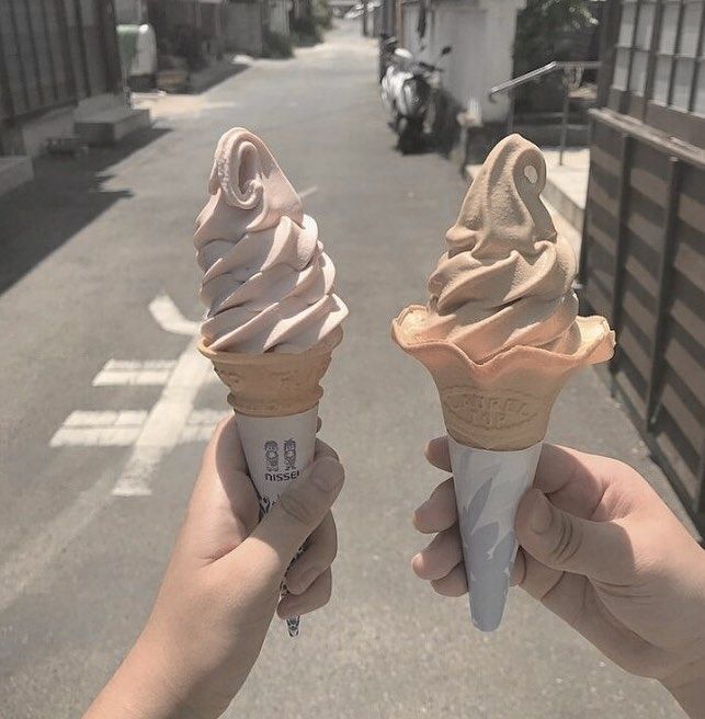 two people holding ice cream cones in their hands