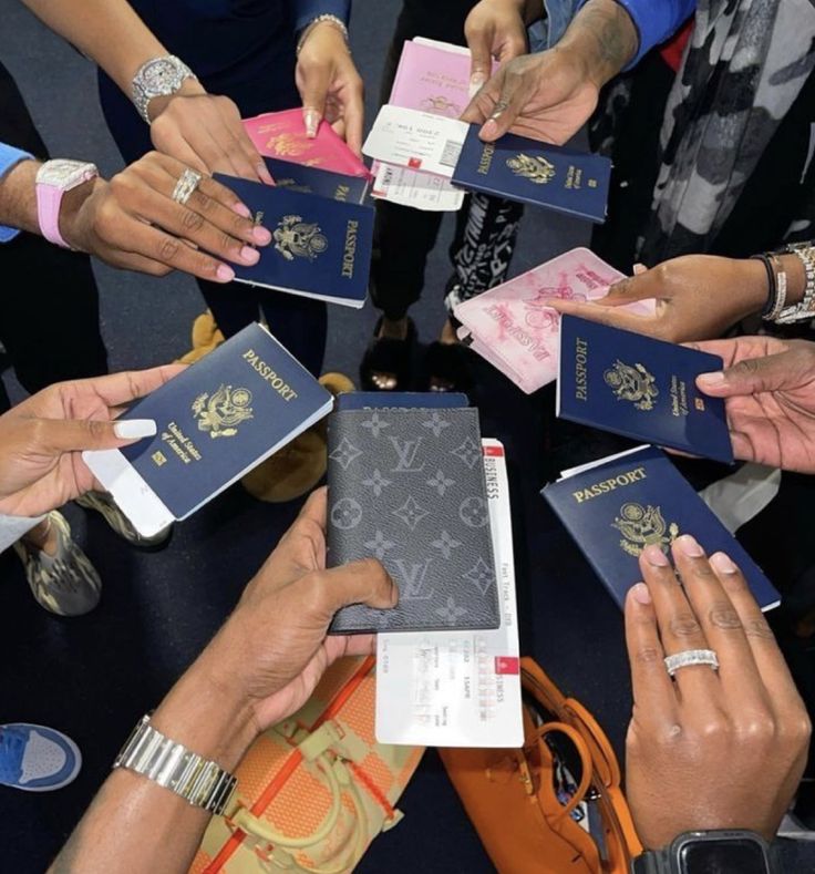 many people are holding their passport in the middle of a circle with one person's hands