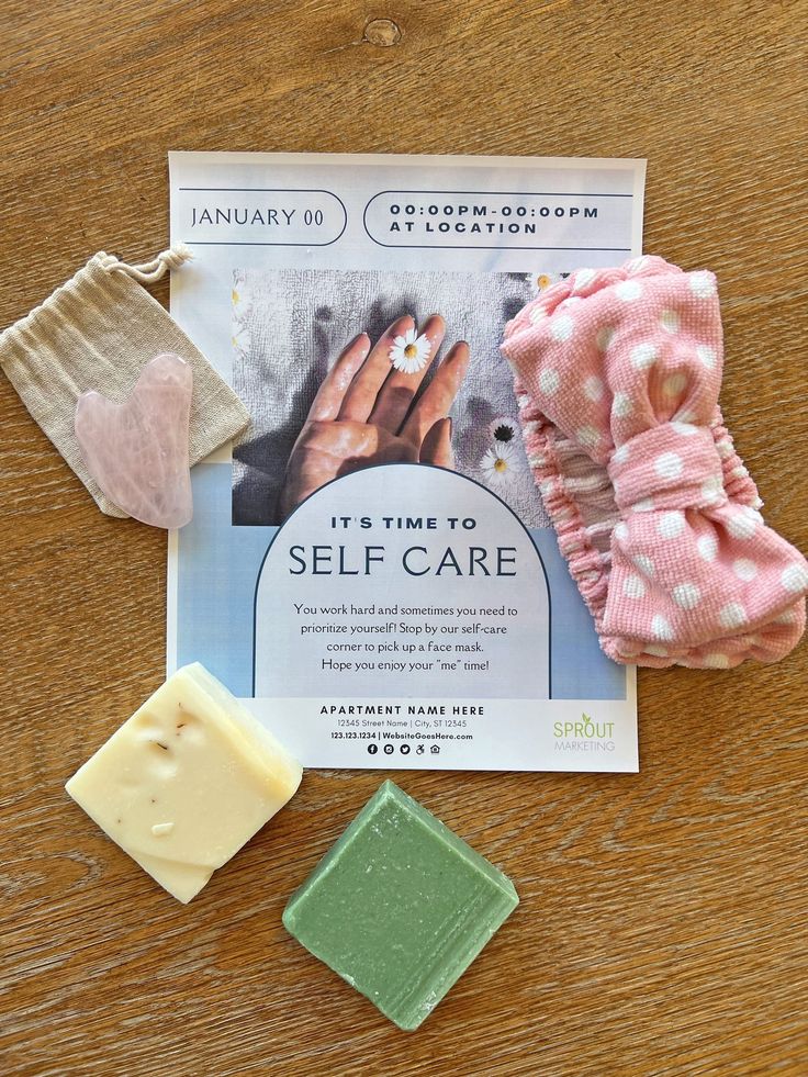 some soaps are sitting on a table with other items around it, including an advertise for self care