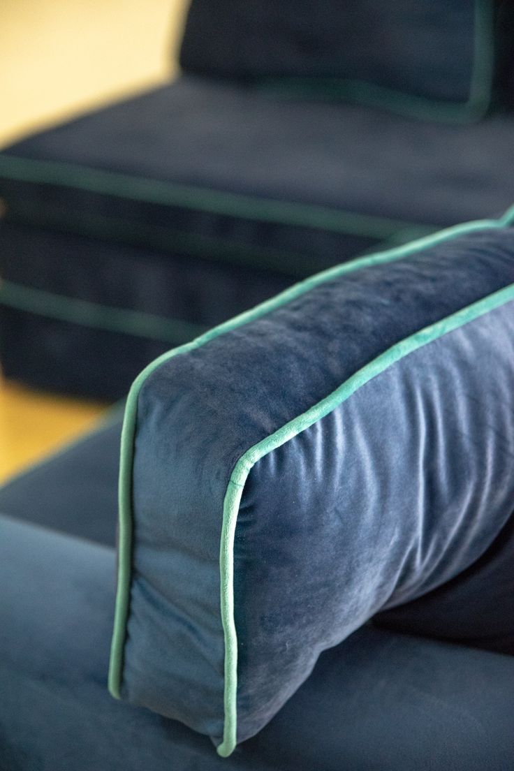 two blue couches sitting next to each other on a wooden floor