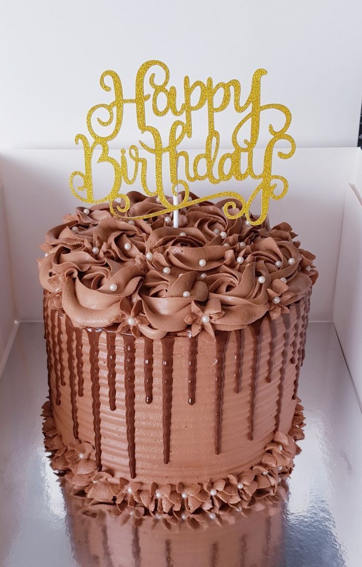 a birthday cake with chocolate frosting and gold letters