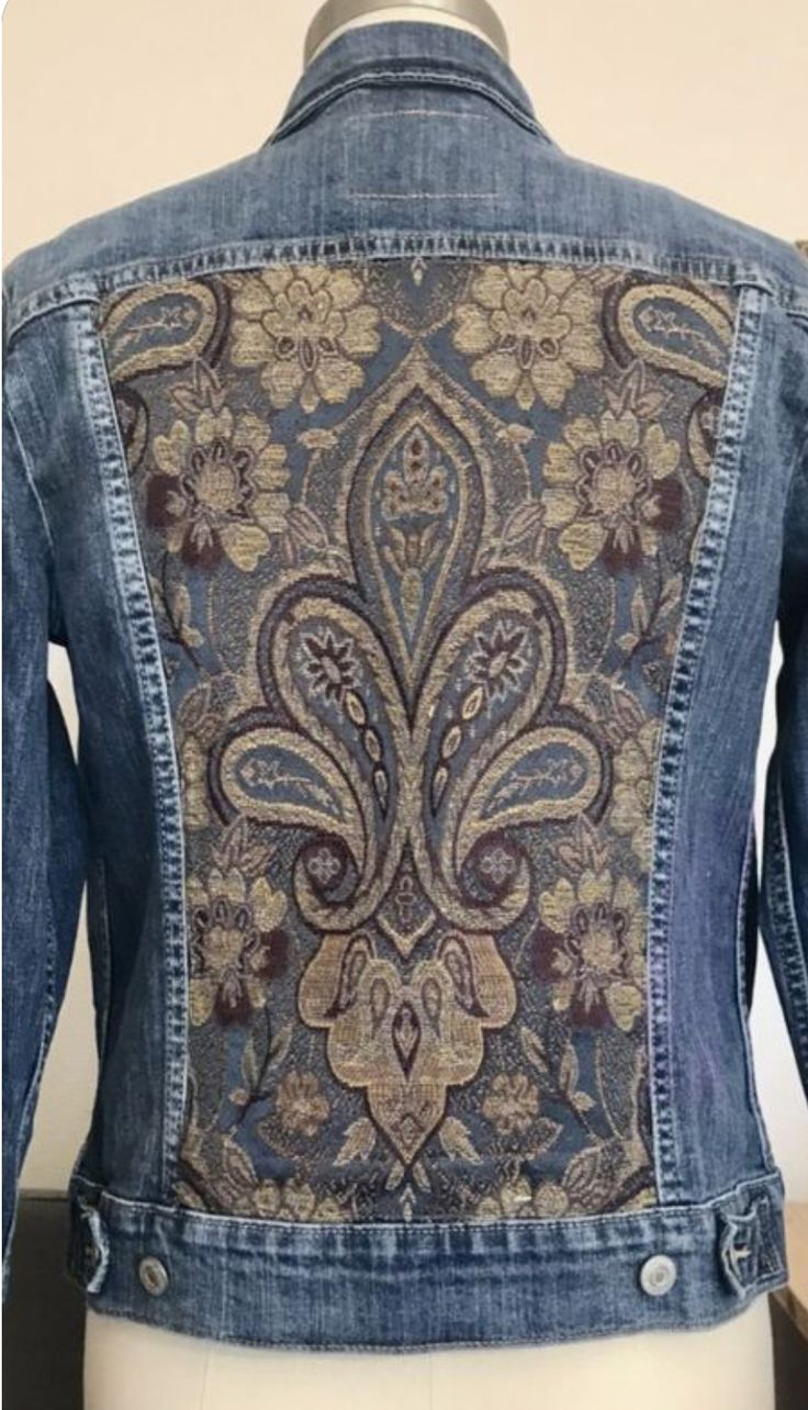 a denim jacket with an intricate design on the back