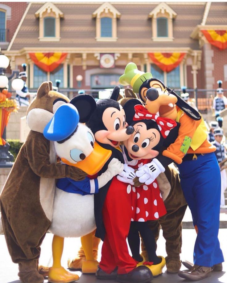 mickey and friends posing for a photo in front of goofy's house