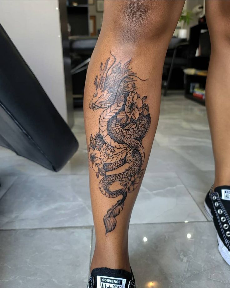 a person with a dragon tattoo on their leg