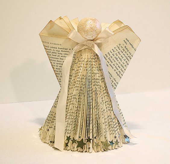 an origami book with a bow on it's head and pages folded in the shape of books