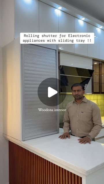 a man is standing at the counter in front of an electronic appliance that says, rolling shutters for electronic appliances with sliding trays