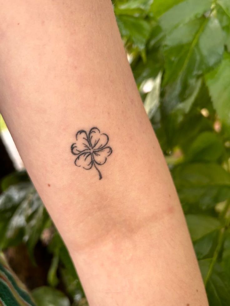 a small four leaf clover tattoo on the arm