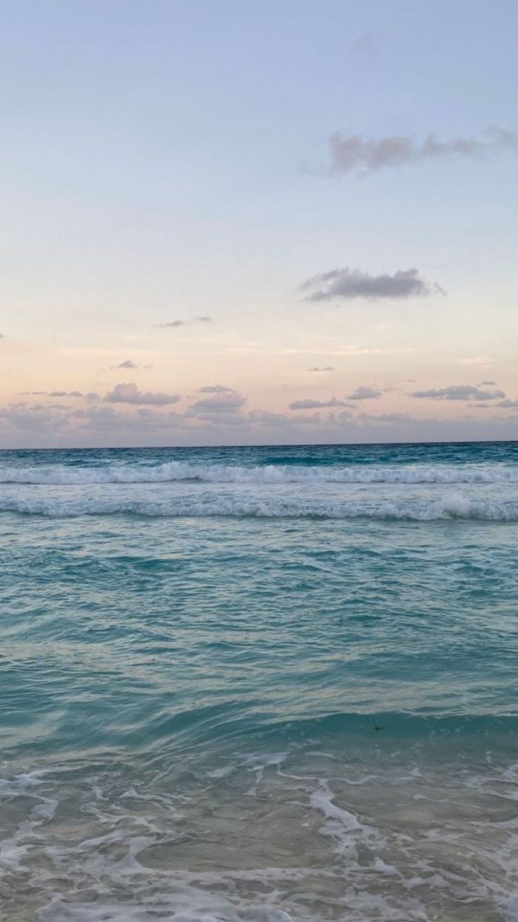 an ocean view with waves coming in to shore