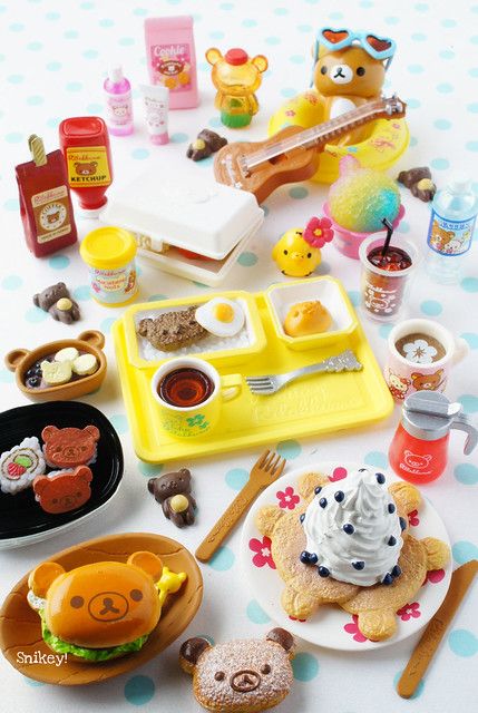 a table topped with lots of toys and plates filled with different foods on top of it