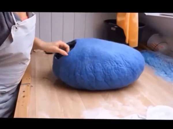 a person is making a large blue bean bag chair