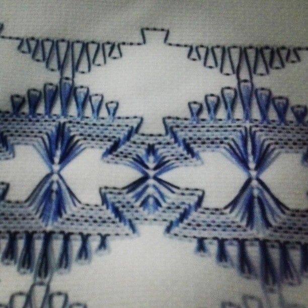 a close up view of some blue and white designs on a piece of cloth that has been stitched together