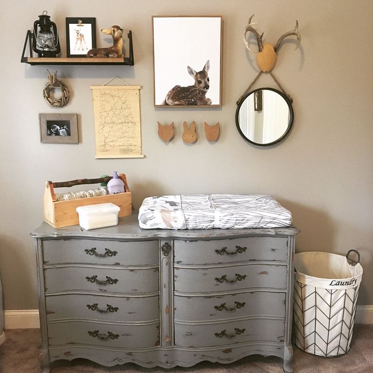 a baby's crib in the corner of a room with pictures on the wall