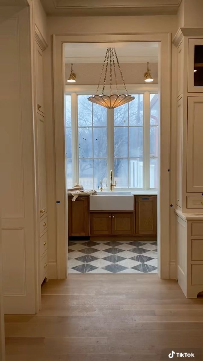 an open door leading to a kitchen with a sink and window