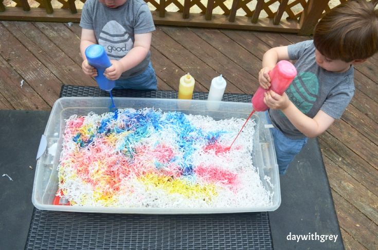 two young boys are playing with an ice cream cake