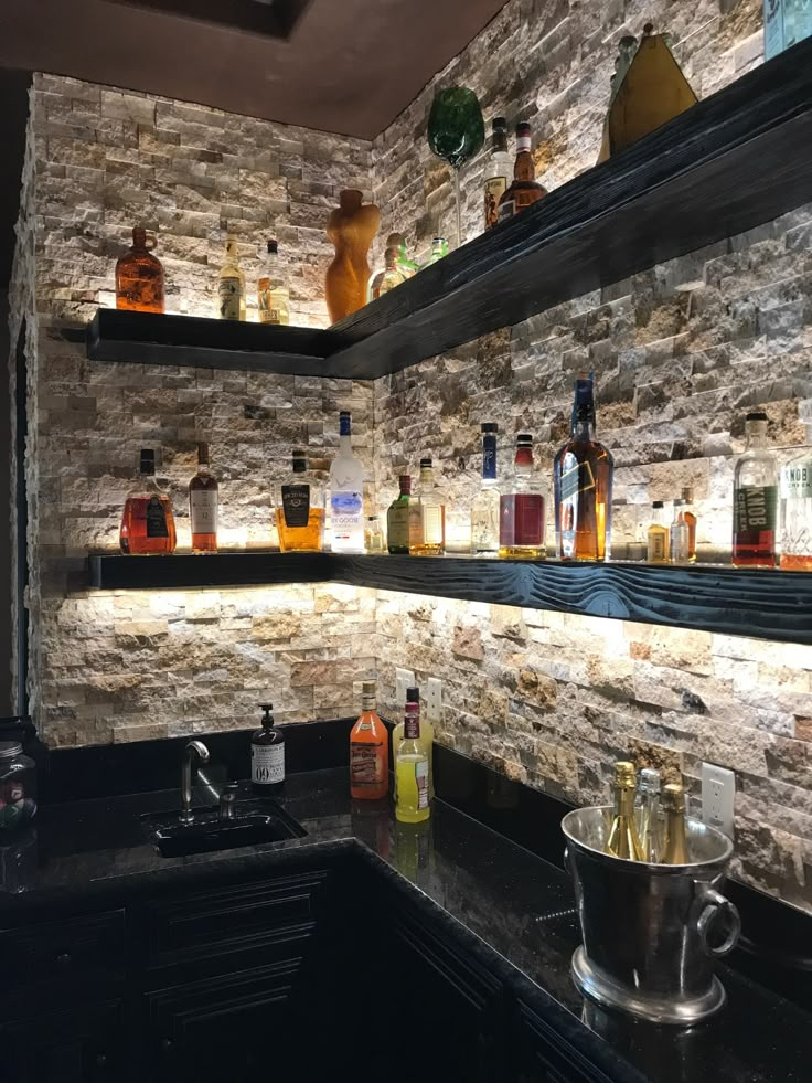 the shelves are filled with liquor bottles and glasses on top of them, along with an ice bucket