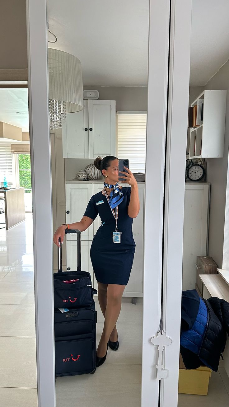 a woman is taking a selfie in the mirror while holding her suitcase and looking at herself