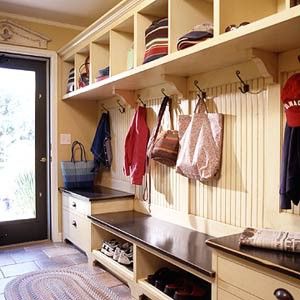 the inside of a baseball dugout with many coats hanging on hooks and shoes in it