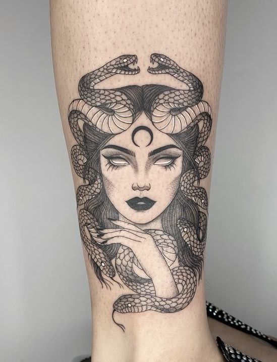 a woman's leg with a snake on it and her face in the middle