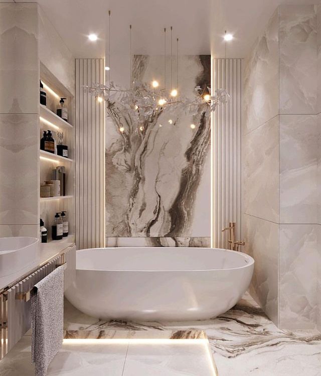 a large white bath tub sitting next to a sink in a room with marble walls