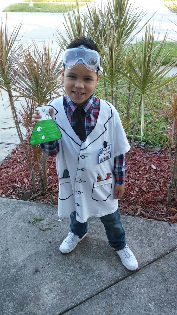 a young boy wearing a white shirt and tie holding a green piece of paper in his hand