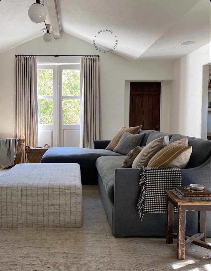 a living room filled with furniture next to a window and a rug on the floor