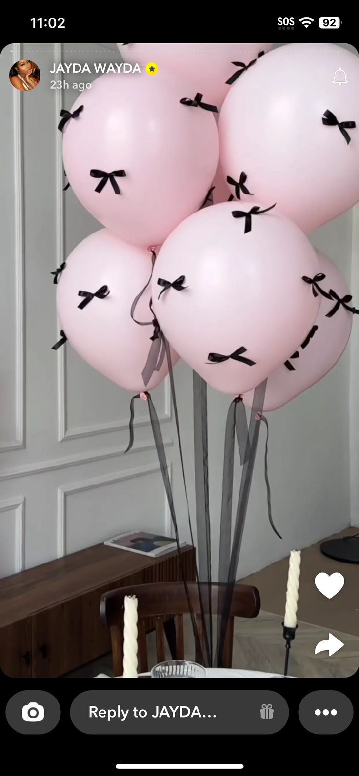 pink balloons with black bows on them in a room