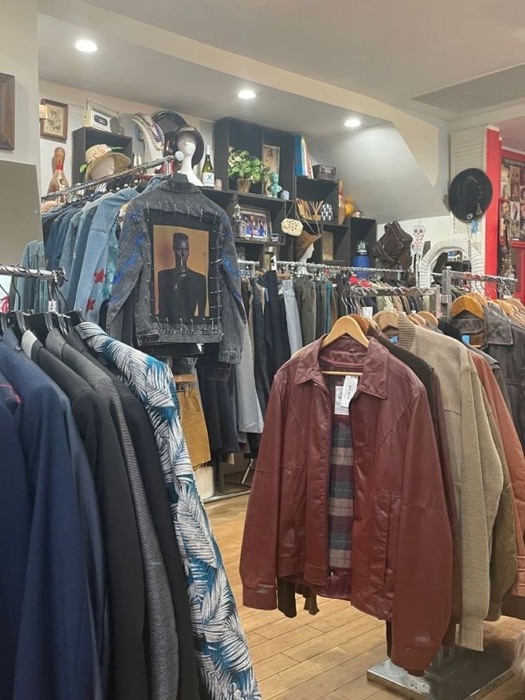 a clothing store filled with lots of clothes and jackets on display next to each other