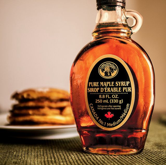 a bottle of maple syrup next to some pancakes