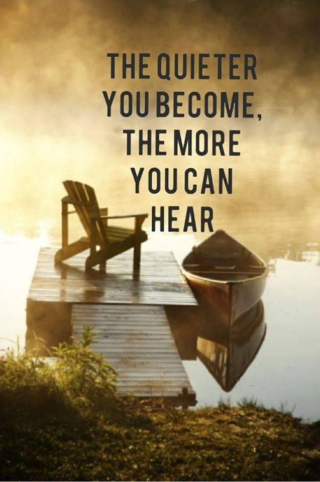 a chair sitting on top of a dock next to a body of water with a boat in it